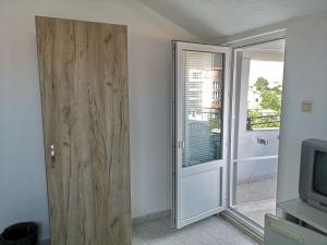 a room with a wooden door and a television at Guestrooms Stoyanovi in Chernomorets