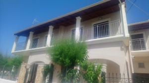 a white house with a balcony on the side of it at Mary's apartments close to the sea in Agios Georgios