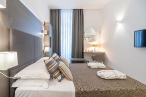 Una habitación de hotel con una cama con dos toallas. en Wellness Home Rome, en Roma