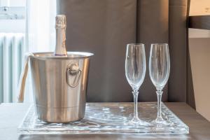 two champagne glasses and a bucket with a bottle in it at Wellness Home Rome in Rome