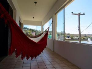 a red hammock in a room with a large window at Recanto do Lago Triunfo in Triunfo