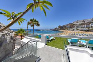 Blick auf den Strand vom Balkon eines Resorts in der Unterkunft BeachFront Suites Morea Puerto Rico by VillaGranCanaria in Puerto Rico de Gran Canaria