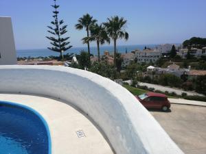 a pool with a car parked in a parking lot at Casablanca Villas in Nerja