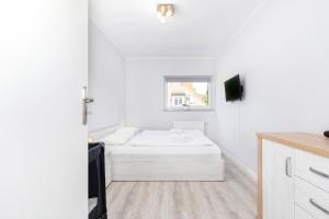 a white bedroom with a bed and a window at Apartament Nowa Flotylla by Renters in Świnoujście