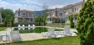 a house with chairs and a pool in the yard at PALACE KIRKPINAR in Sakarya