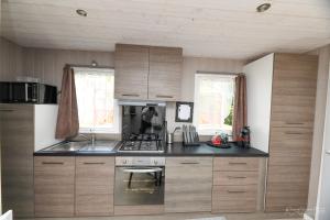 a kitchen with wooden cabinets and a stove top oven at Dallas in Sallertaine