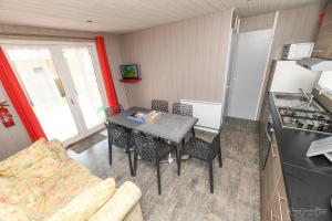 a small kitchen with a table and chairs in a room at Dallas in Sallertaine