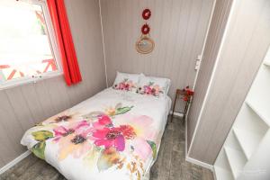 a small bedroom with a bed with a floral bedspread at Dallas in Sallertaine