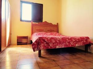 a bedroom with a bed with a red blanket on it at Recanto do Lago Triunfo in Triunfo