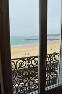 uma vista para a praia a partir de uma janela em Ayenac em Saint-Jean-de-Luz