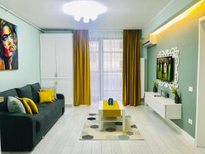 a living room with a couch and a tv at DarNiDa Luxury Apartment in Mamaia Sat/Năvodari