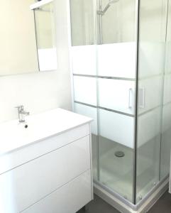 a white bathroom with a sink and a shower at Appartement 4 couchages, 100 mètres de la mer ! in Les Sables-dʼOlonne