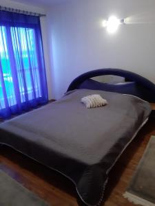 een groot bed in een slaapkamer met een zwarte sprei bij Apartment Brcko Distrikt in Brčko