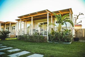 a house with a porch and a grass yard at Camping Vallecrosia in Vallecrosia