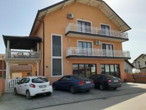 drie auto's geparkeerd voor een gebouw bij Apartment Brcko Distrikt in Brčko