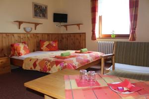 a hotel room with a bed and a table with a table sidx sidx at Pension Horske Zatisi in Horni Misecky