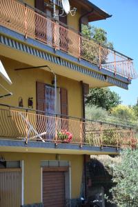 a yellow building with a balcony with flowers on it at Tra gli ulivi da Giacinta in Varazze