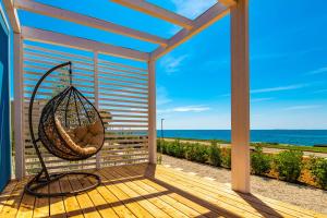 a porch with a hammock and a view of the ocean at Arena Grand Kazela Camping Homes in Medulin