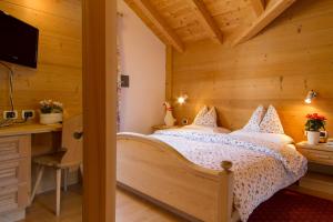 1 dormitorio con 1 cama en una habitación de madera en Chalet Madrisa, en Corvara in Badia