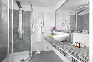 a white bathroom with a sink and a shower at Central Suites Mykonos in Mýkonos City