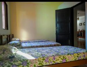 a bedroom with two beds and a door at Recanto do Lago Triunfo in Triunfo