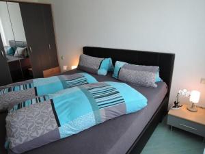 ein Schlafzimmer mit einem großen Bett mit blauen und grauen Kissen in der Unterkunft Haus Eisele in Bad Urach