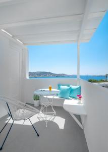 a white room with a table and a chair at Central Suites Mykonos in Mýkonos City
