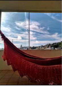 a hammock in front of a window with a view at Recanto do Lago Triunfo in Triunfo