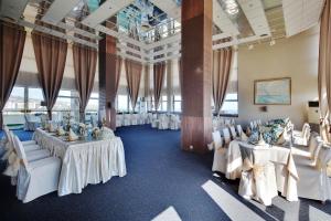 a banquet hall with white tables and white chairs at Hotel & Casino Cherno More in Varna City