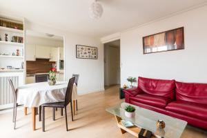 a living room with a red couch and a table at Veeve - Canal Saint Martin Pad in Paris