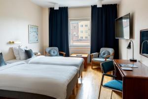 a hotel room with a bed and a desk at First Hotel Statt Örnsköldsvik in Örnsköldsvik