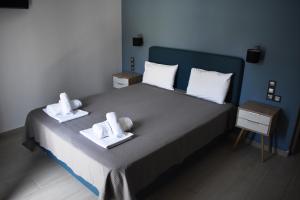 a hotel room with a bed, desk, and nightstand at Christina Studios & Apartments in Parga