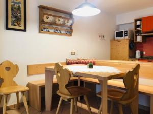 kuchnia ze stołem i krzesłami w pokoju w obiekcie Appartamenti Cesa Maria Mountain Hospitality w mieście Canazei