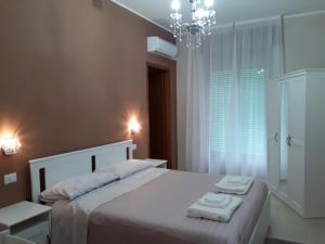 1 dormitorio con 1 cama grande y 2 toallas. en B&B La Giara, en Piedimonte Etneo