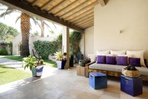 a living room with a couch on a patio at Le Pre de la Mer in Saint-Tropez +37 photos
