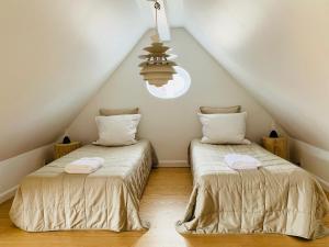 two beds in a attic room with a ceiling at Luxury apartment in the heart of Copenhagen in Copenhagen