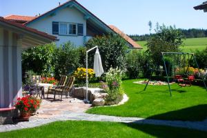 a garden with a table and an umbrella at Ferienwohnung Kolb in Isny im Allgäu