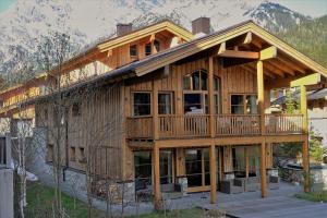 a large wooden house with mountains in the background at Chalet on the Lake in Hinterthal