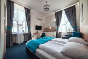 een hotelkamer met een groot bed en ramen bij Villa Centro in Oświęcim