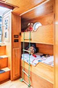 
a child in a bunk bed in a room at The Four Sisters Boatel - Houseboat in Edinburgh
