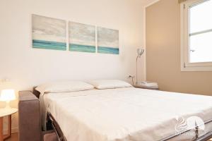 a bedroom with a bed with two paintings on the wall at Studio Apartment Il Pelèr in Toscolano Maderno