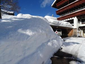 a pile of snow in front of a house at Der Berghof in Hirschegg