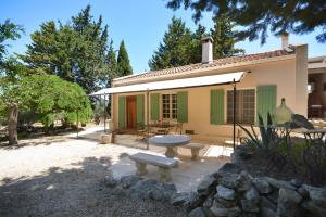 a house with a table and a bench in front of it at les mazets de la reine Pédauque in Paradou