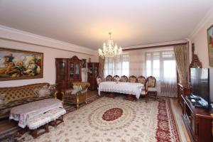 a living room with a couch and a table and chairs at Apartments Emili in Yerevan