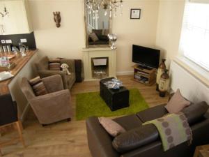a living room with a couch and a television at Knights Rest Conwy Town 5 Star in Conwy