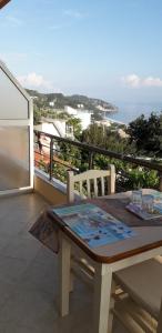 una mesa en un balcón con vistas al océano en Dhori House Dhermi, en Dhërmi