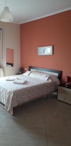 una camera con un grande letto con una parete rossa di Dhori House Dhermi a Dhërmi