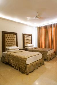 
a hotel room with two beds and two lamps at City View Hotel & Restaurant in Lahore
