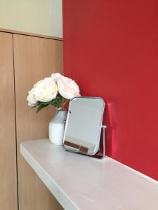 a vase of flowers and a mirror on a shelf at Summerfield House in Birmingham