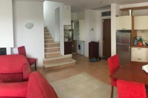 uma cozinha e sala de estar com cadeiras vermelhas e uma mesa em Exclusive Big Villa em Byala